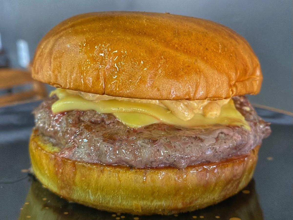 Hambúrguer artesanal da Confit Burguer com queijo derretido e blend bovino grelhado